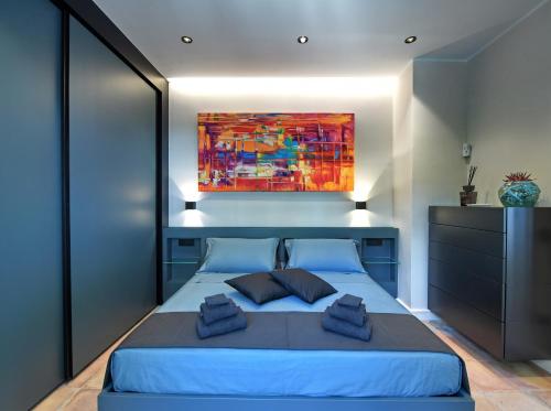 a bedroom with a blue bed with a painting on the wall at Mira Suite in Vietri sul Mare