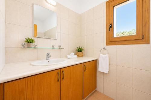a bathroom with a sink and a mirror at Villa Androulla in Argaka