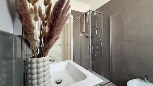 a bathroom with a vase with feathers in it at Soffio del Mar in Pila