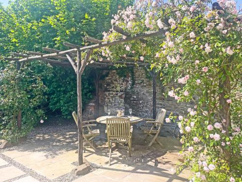 a table and chairs under a wooden pergola at The Haven in Ludlow