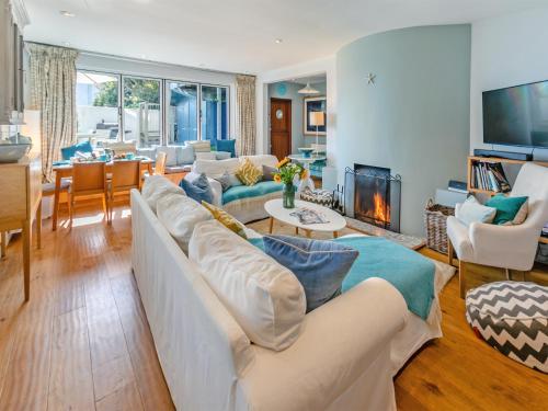 a living room with a white couch and a fireplace at Dolphins Reach in Saint Mawes