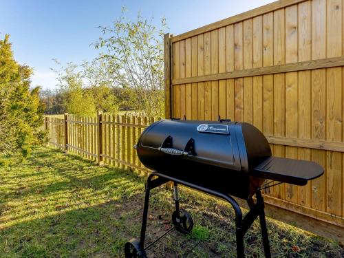 a black barbecue grill sitting next to a fence at Bluebell Lodge-Uk32958 in Molash