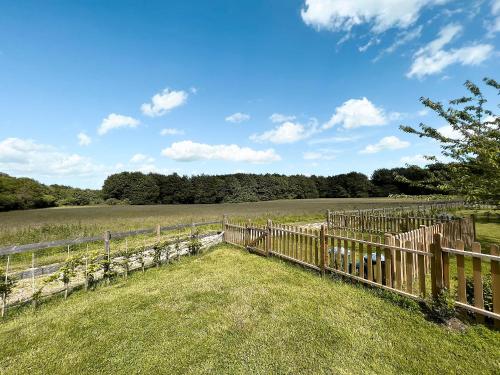 a wooden fence in the middle of a field at Bluebell Lodge-Uk32958 in Molash