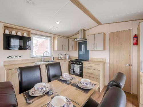 a kitchen with a wooden table with chairs and a dining room at Hallcroft Fishery in Retford