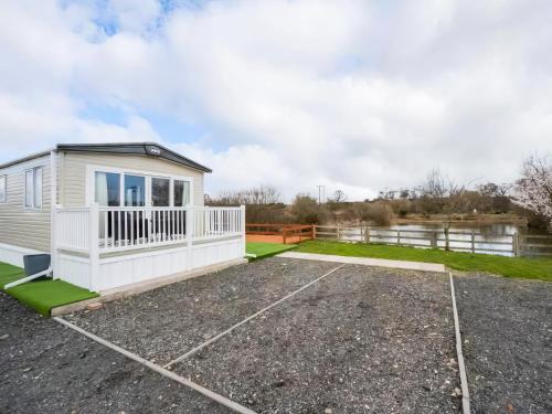 a caravan conversion with a car park in front of a lake at Hallcroft Fishery in Retford