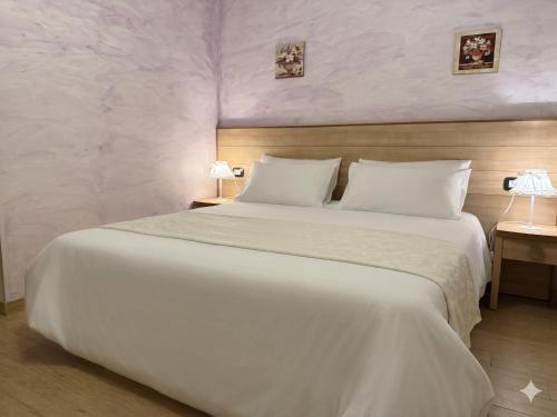a bedroom with a large bed with white sheets at Le Essenze - Agriturismo con vista in Cesena