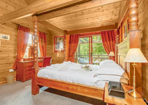 a bedroom with a large bed in a log cabin at Tilford Woods Lodge Retreat in Hurley