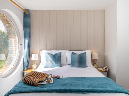 a bedroom with a bed with blue pillows and a window at Owls Rest - Iua in Cayton