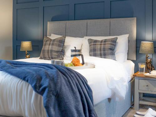 a white bed with a bowl of fruit on it at Dovecote House-Uk30233 in Cayton