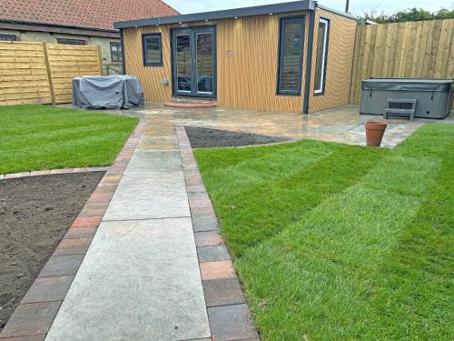 a garden with a lawn and a house at Ashtree Hideaway in Brandon
