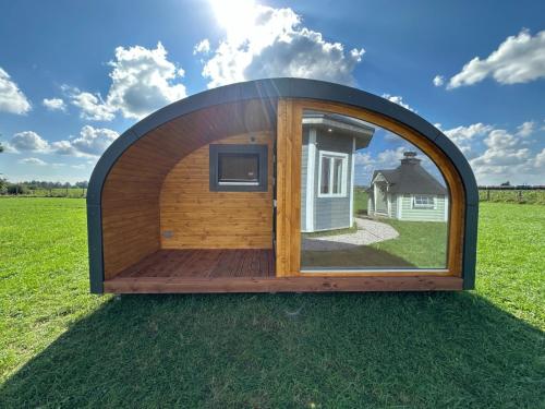 a circular house with a large window in a field at POD mit Bad 84 in Hüde