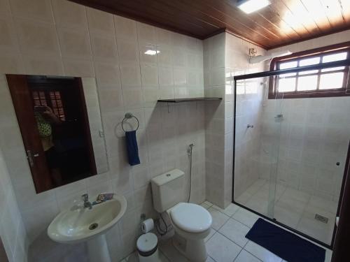 a bathroom with a shower and a toilet and a sink at Casarão do Mar in Cabo Frio