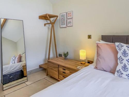 a bedroom with a bed and a mirror at Gardeners Cottage - Uk51831 in Great Ayton