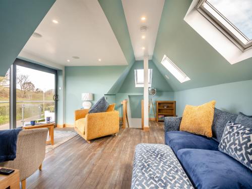 a living room with blue walls and skylights at Blodfryn in Llandudno Junction