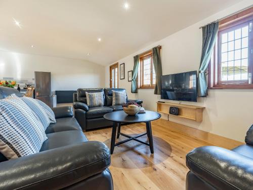 a living room with leather furniture and a tv at Snowdrop Lodge -Uk32959 in Molash