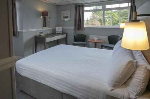 a hotel room with a bed and a table and chairs at Best Western New Kent Hotel in Newcastle upon Tyne