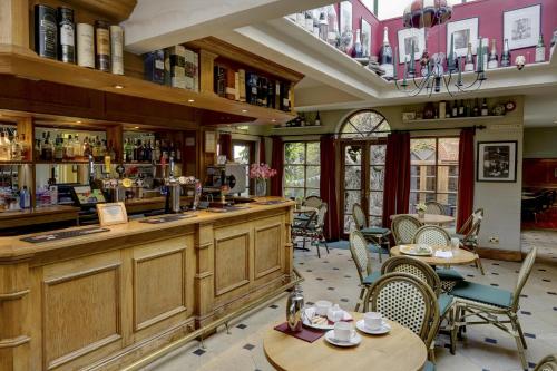 a restaurant with tables and chairs and a bar at York Pavilion Hotel, BW Signature Collection in York