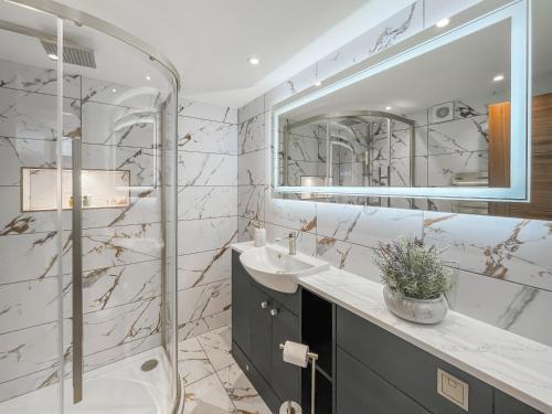 a bathroom with a shower and a sink and a mirror at West Mains Barn - Uk51957 in Kilbirnie