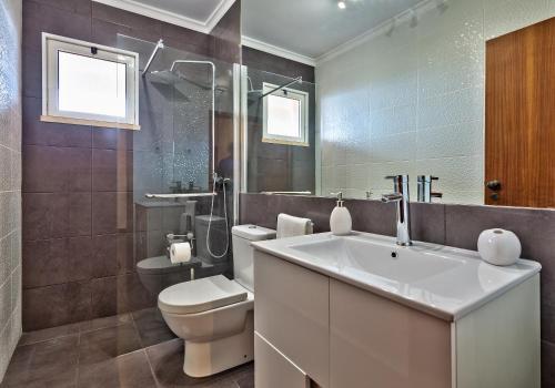 een badkamer met een witte wastafel en een toilet bij Golden Place Apartment in Funchal