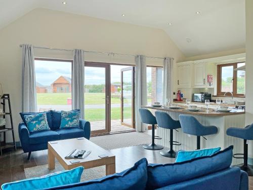 a living room with a blue couch and a kitchen at Jasmine Lodge in Garton
