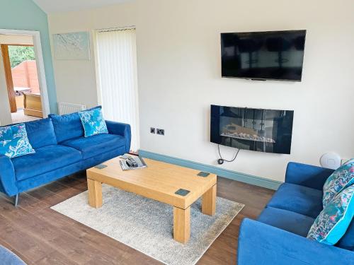 a living room with a blue couch and a coffee table at Jasmine Lodge in Garton