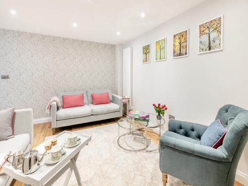 a living room with two couches and a table at Anne's Cottage in Strines