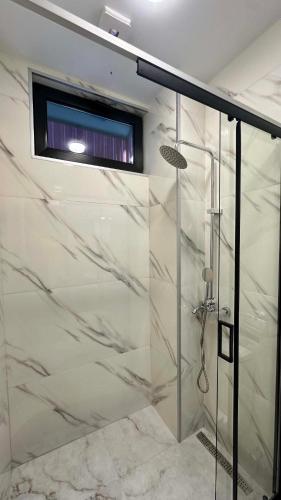 a shower with a glass door in a bathroom at Hotel Nena in Kobuleti