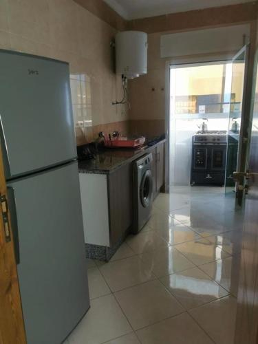 a kitchen with a refrigerator and a washing machine at Martil calm apartment in Martil