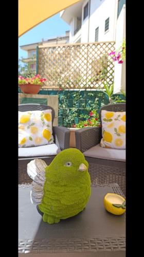 a green stuffed bird sitting on top of a table at Domus REA Bracciano - Self Check-in H24 in Bracciano
