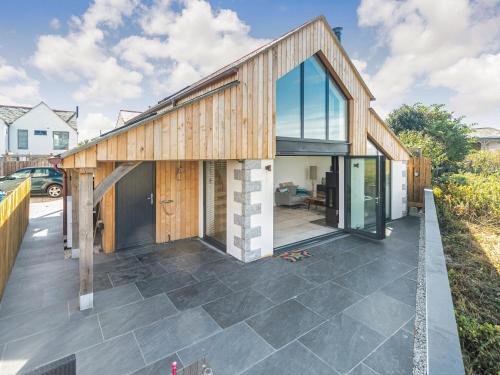 a house with glass doors on a patio at The Old Coach Garage in Gerrans