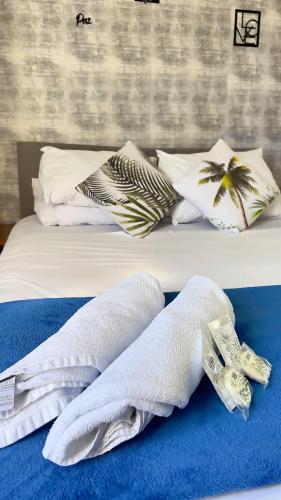 a bed with white towels on a blue blanket at Pousada Tribo Ubatuba in Ubatuba