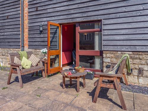a patio with two chairs and a table and a building at Granary - Uk49910 in Blandford Forum