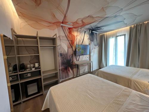 a bedroom with two beds and a painting on the wall at Feel Good in Rimini