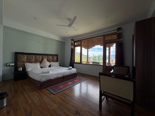 a bedroom with a bed and a large window at Mandalchan hotel in Leh