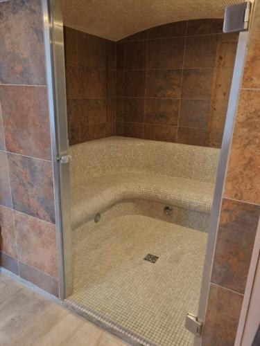 a shower with a glass door in a bathroom at La Casa des Frangins in Saint-Romain-de-Colbosc