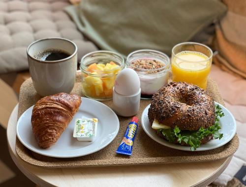 a breakfast tray with a donut and croissants and orange juice at Hotel With Urban Deli in Stockholm