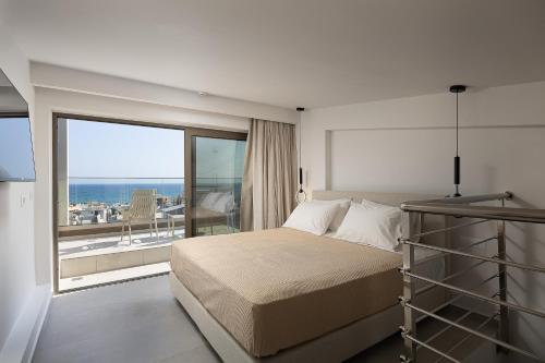 a bedroom with a bed and a large window at Solianna Rethymno Suites in Rethymno