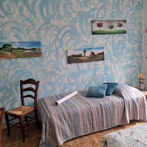 a bedroom with a bed and a chair at Cà dl'Ernesto in Varallo