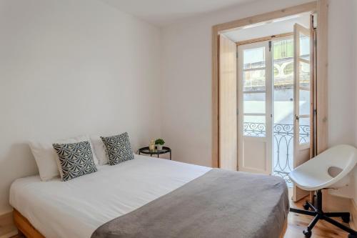 a bedroom with a bed and a chair and a window at LOVELY Central Apartment 3Bdr by Vinum Apartment 1890 in Coimbra