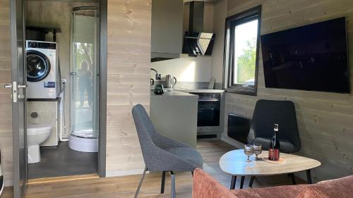 a small kitchen with a table and chairs in a tiny house at Hjertero - Hide Away Suite in Sortland