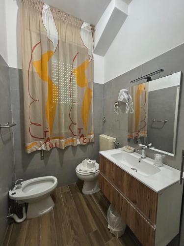 a bathroom with a toilet and a sink at HOTEL CONCORDIA in Montecatini Terme