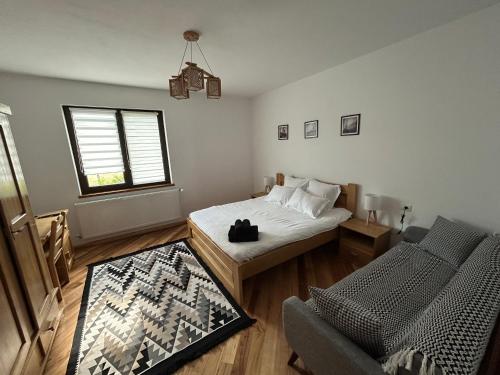 a bedroom with a bed and a chair and a window at Cacica Holiday in Cacica
