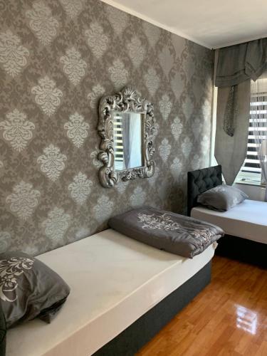 a bedroom with two beds and a mirror on the wall at Unterkunft Mara in Oberhausen