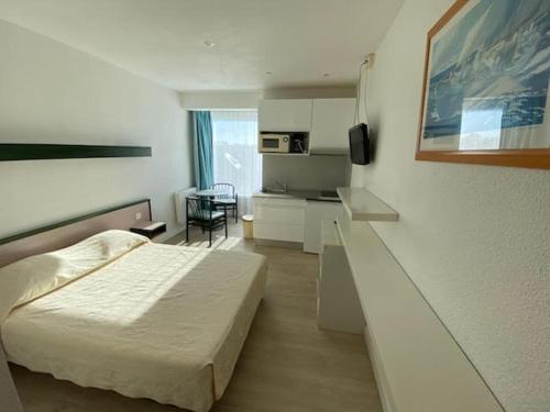 a hotel room with a bed and a kitchen at BELLE VUE MER STUDIO PISCINE in Trévou-Tréguignec