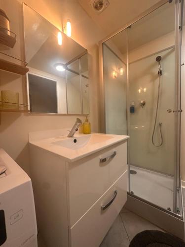 a bathroom with a sink and a shower with a mirror at Pure comfort in Entrelacs