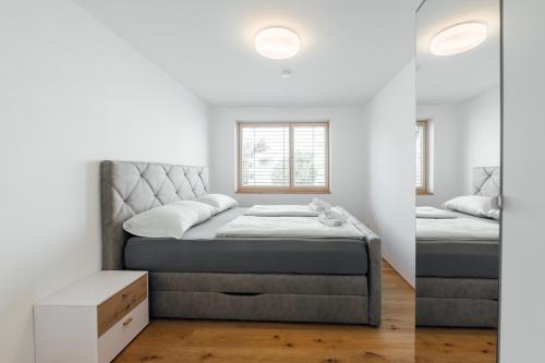 two beds in a room with white walls at Bodensee Bergblick Nest by Stadtlandnest in Lochau