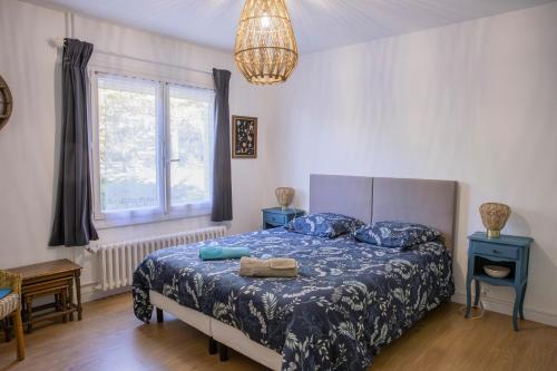 a bedroom with a bed with blue sheets and a window at Clos Sainte Anne avec piscine in Cour-Cheverny