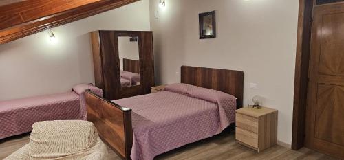 a bedroom with two beds and a mirror at Casa Delia in Piazzano