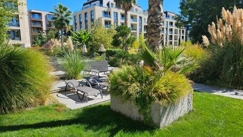 a garden with a table and chairs and a building at Azur Pearl by RV Apartments in Saints Constantine and Helena