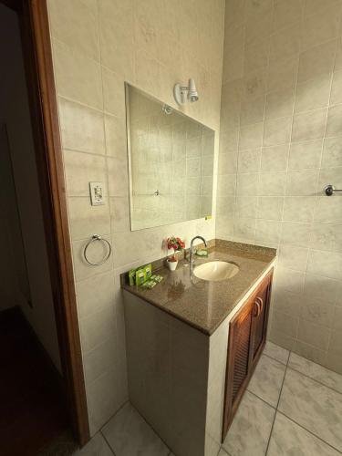 a bathroom with a sink and a mirror at Pousada Luar da Serra in Valença